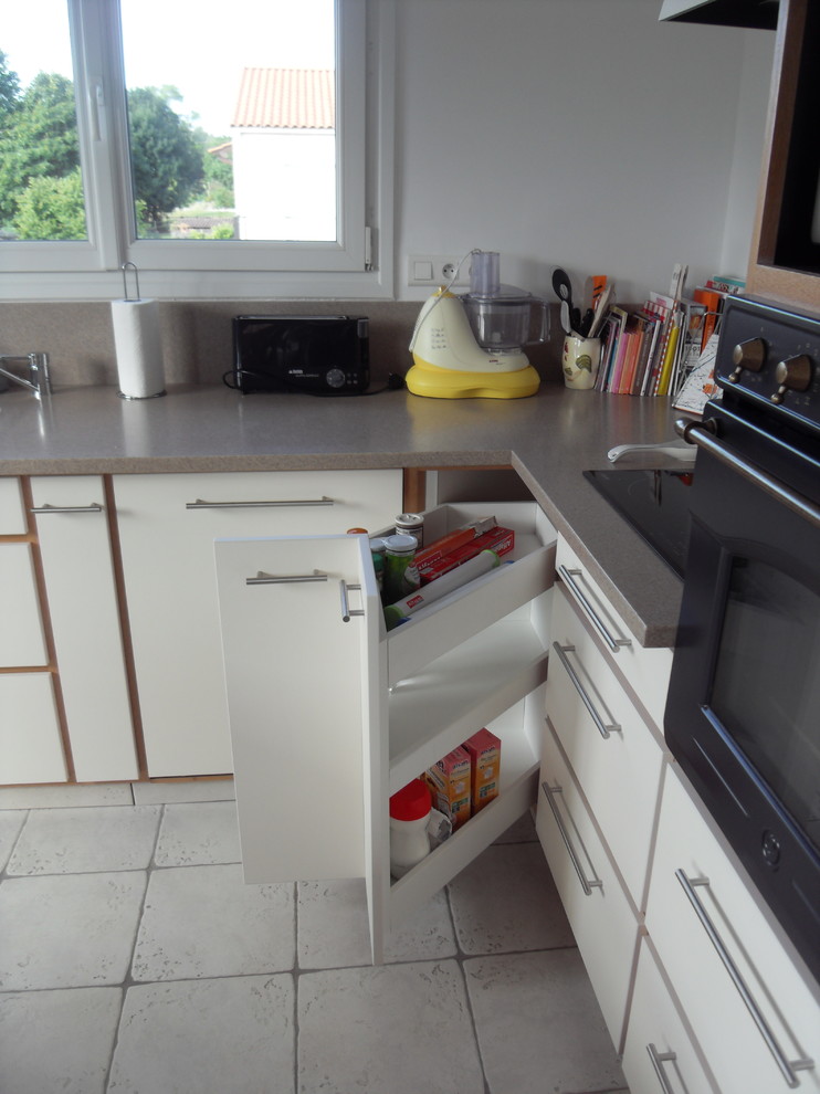 Exempel på ett modernt kök, med en undermonterad diskho, släta luckor, beige skåp, bänkskiva i koppar, beige stänkskydd, svarta vitvaror, klinkergolv i keramik, en köksö och grått golv