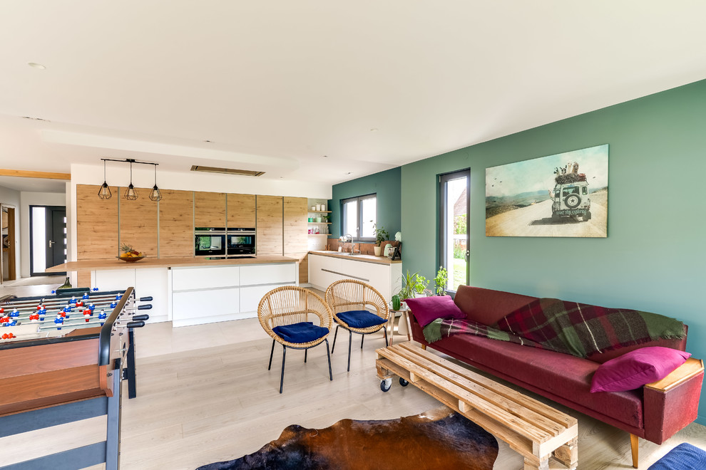 Bild på ett funkis kök, med en dubbel diskho, skåp i ljust trä, laminatbänkskiva, stänkskydd i mosaik, rostfria vitvaror, betonggolv, en köksö och beiget golv