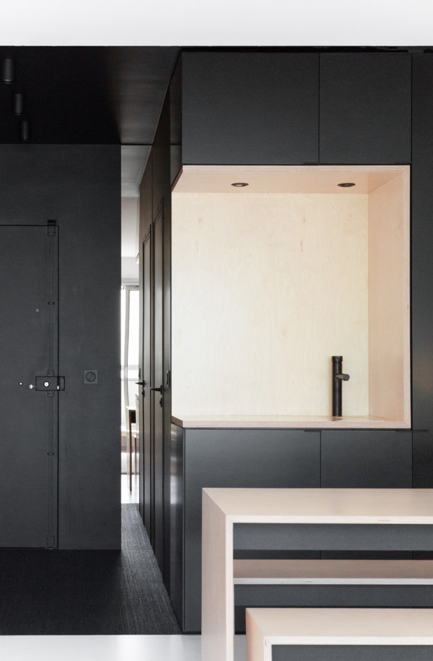 Exempel på ett mellanstort modernt beige linjärt beige kök med öppen planlösning, med en undermonterad diskho, släta luckor, svarta skåp, träbänkskiva, beige stänkskydd, stänkskydd i trä, integrerade vitvaror, heltäckningsmatta och svart golv