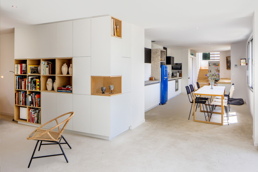 Inspiration for an expansive contemporary single-wall open plan kitchen in Marseille with black cabinets, concrete worktops, white splashback, coloured appliances, concrete flooring, no island, beige floors and grey worktops.
