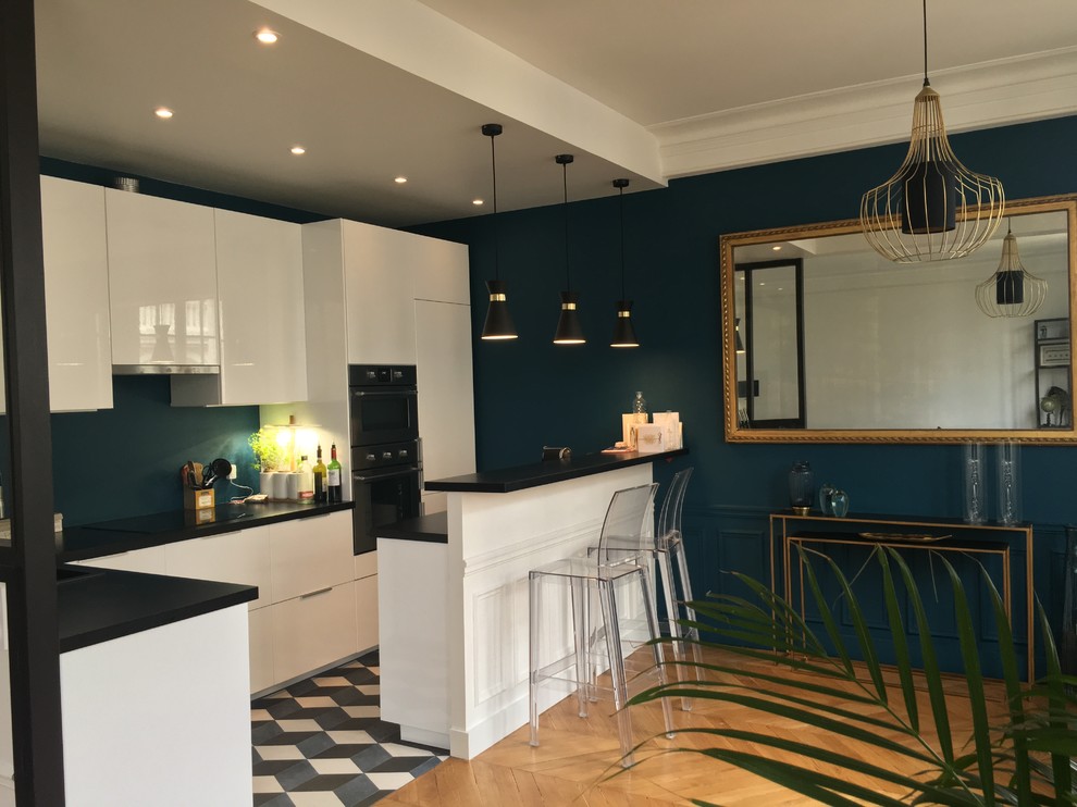 Immagine di una cucina classica di medie dimensioni con ante lisce, ante bianche, top in laminato, paraspruzzi blu, elettrodomestici in acciaio inossidabile, pavimento in cementine, penisola, pavimento blu e top nero