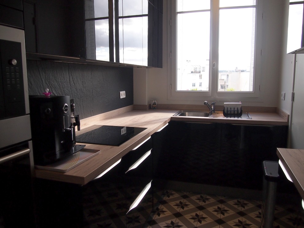 Cette image montre une petite cuisine encastrable design en L fermée avec un évier posé, des portes de placard noires, un plan de travail en stratifié, une crédence noire, une crédence en ardoise, un sol en carrelage de céramique et un sol gris.