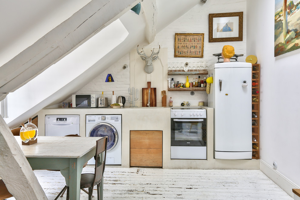 パリにある北欧スタイルのおしゃれなキッチン (アンダーカウンターシンク、白い調理設備、塗装フローリング、アイランドなし、白い床、ベージュのキッチンカウンター) の写真