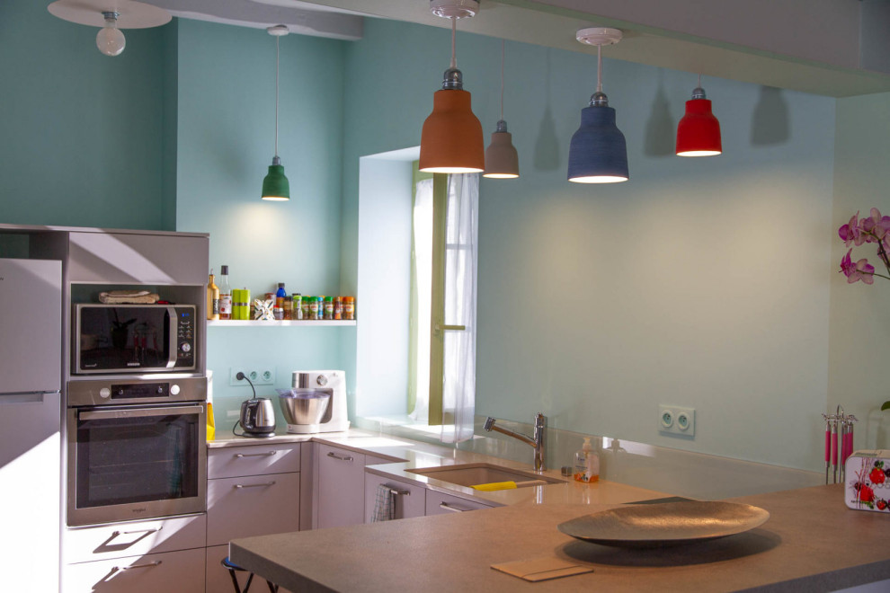 Foto di una cucina country di medie dimensioni con lavello a doppia vasca, top in laminato, paraspruzzi verde, paraspruzzi con lastra di vetro, pavimento in terracotta, ante a filo, ante beige e top beige