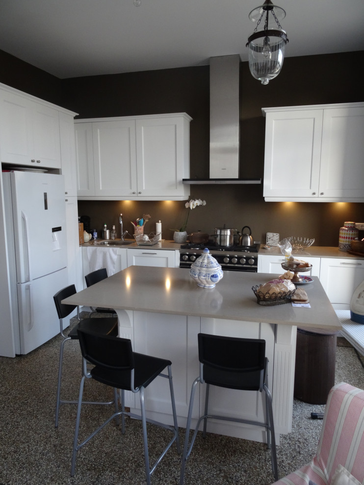 Foto på ett mellanstort vintage beige kök, med en integrerad diskho, luckor med profilerade fronter, vita skåp, bänkskiva i kvartsit, brunt stänkskydd, svarta vitvaror, terrazzogolv och en köksö
