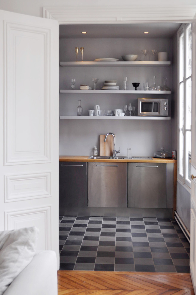 Geschlossene, Einzeilige Moderne Küche ohne Insel mit integriertem Waschbecken, Edelstahlfronten, Arbeitsplatte aus Holz, Küchenrückwand in Grau und braunem Holzboden in Lyon