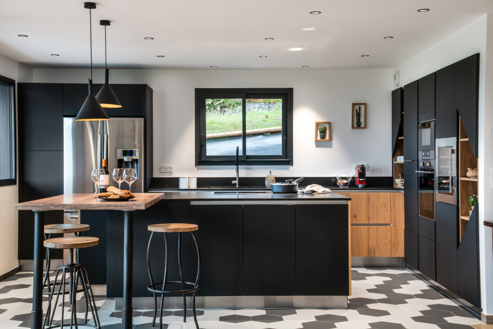 Exempel på ett stort skandinaviskt svart svart kök, med en integrerad diskho, luckor med profilerade fronter, svarta skåp, granitbänkskiva, svart stänkskydd, rostfria vitvaror, klinkergolv i keramik och grått golv