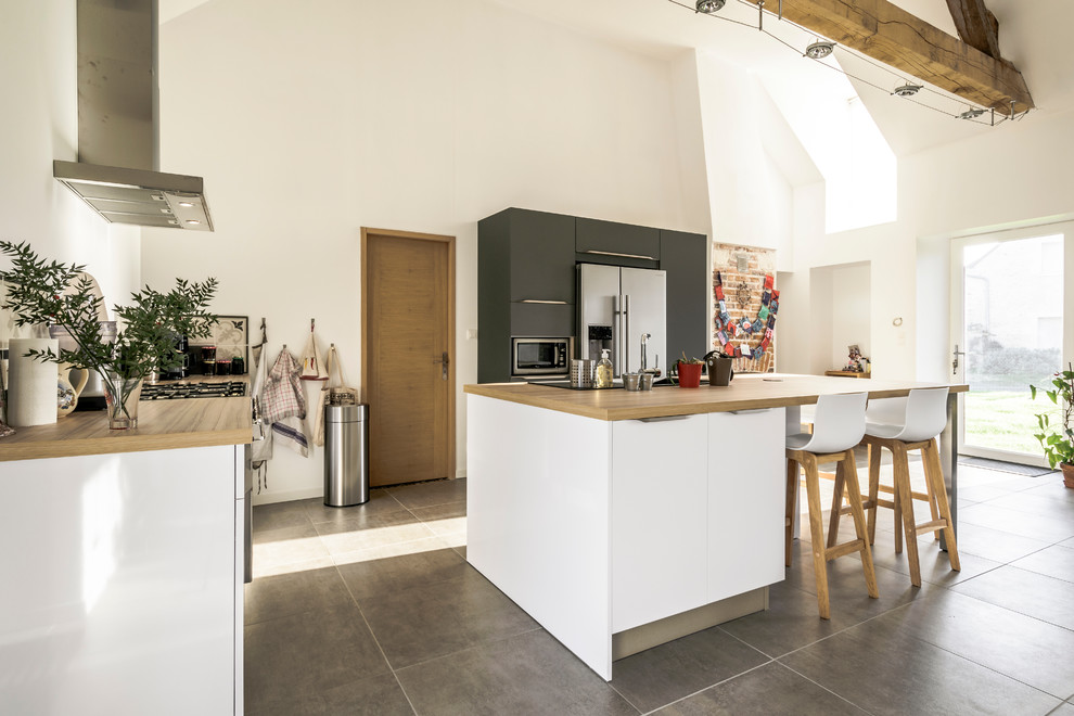 Minimalistisk inredning av ett mellanstort kök, med vita skåp, laminatbänkskiva, stänkskydd i cementkakel, rostfria vitvaror och en köksö