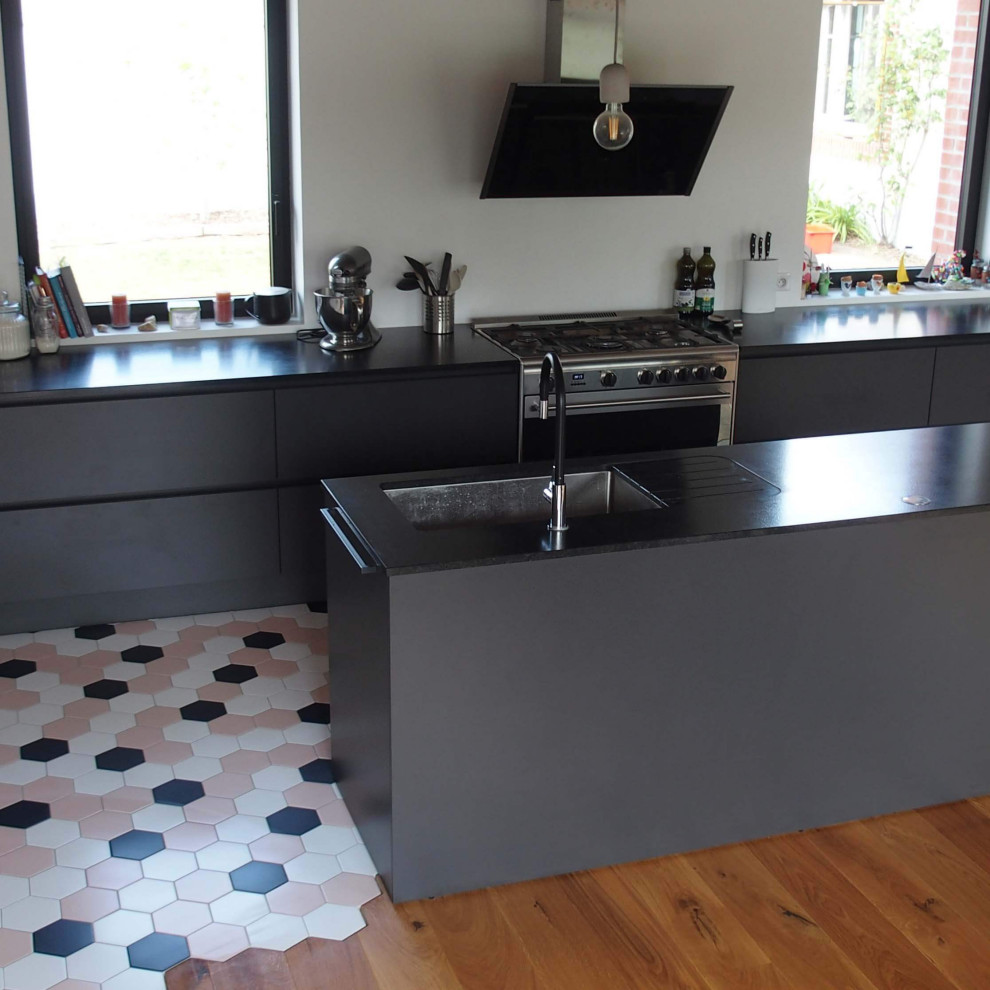 Idéer för att renovera ett stort funkis svart svart kök, med en undermonterad diskho, granitbänkskiva, rostfria vitvaror, cementgolv, en köksö och flerfärgat golv