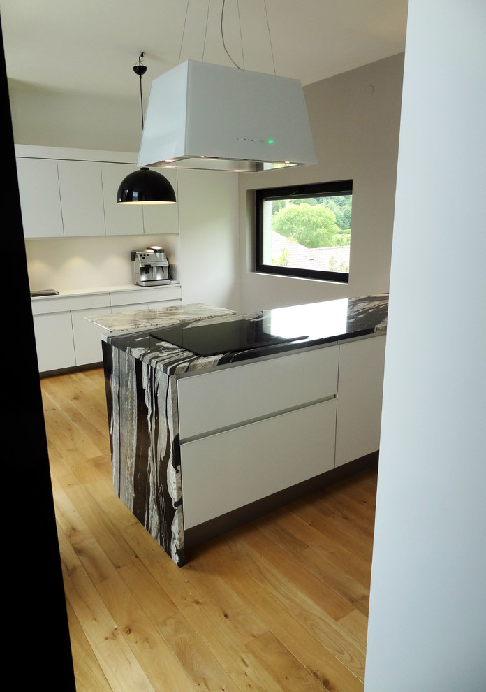 Esempio di una cucina design di medie dimensioni con lavello a vasca singola, top in granito, elettrodomestici in acciaio inossidabile e parquet chiaro