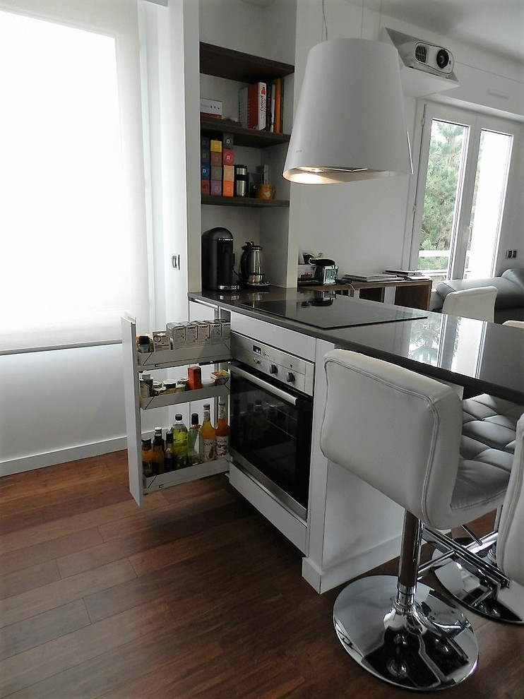 Foto di una cucina contemporanea di medie dimensioni con lavello sottopiano, ante a filo, elettrodomestici in acciaio inossidabile e parquet scuro