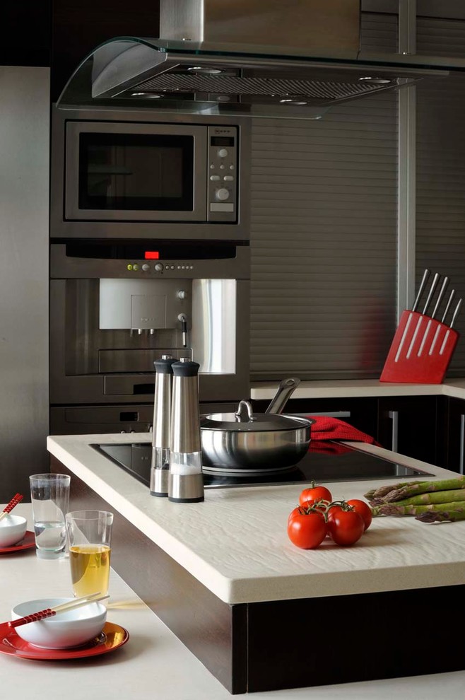 Modelo de cocinas en L contemporánea pequeña con fregadero encastrado, armarios con paneles lisos y encimera de madera
