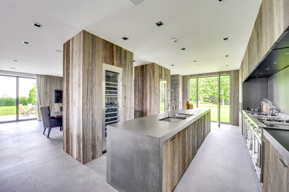 Large contemporary single-wall open plan kitchen in Paris with a submerged sink, flat-panel cabinets, distressed cabinets, stainless steel appliances, an island and ceramic flooring.