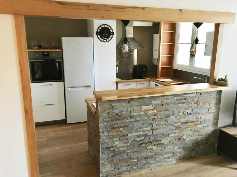 Immagine di una cucina minimal di medie dimensioni con ante bianche, top in legno, paraspruzzi grigio, paraspruzzi con piastrelle di metallo, elettrodomestici in acciaio inossidabile e parquet chiaro
