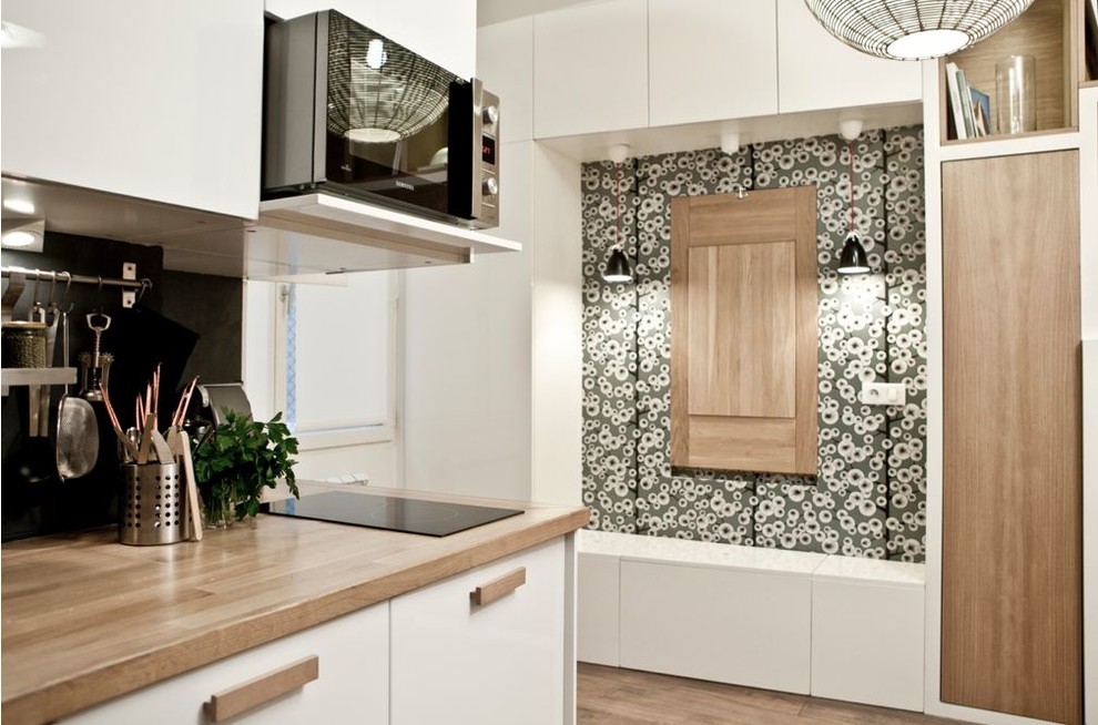 Einzeilige, Mittelgroße Moderne Wohnküche ohne Insel mit weißen Schränken und braunem Holzboden in Paris
