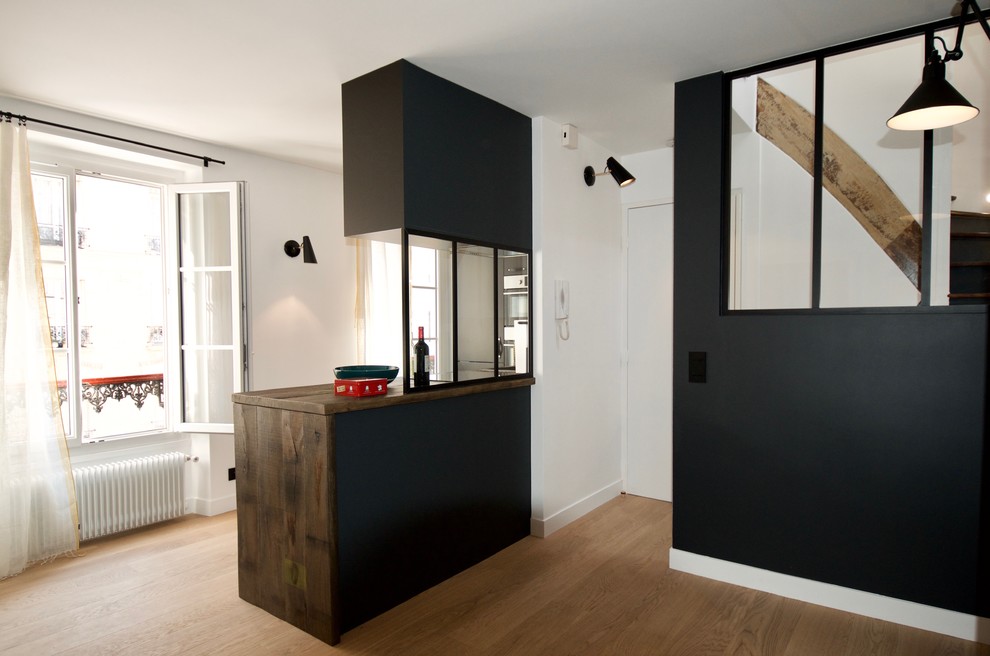 Bild på ett litet funkis kök, med luckor med profilerade fronter, svarta skåp, träbänkskiva, vitt stänkskydd, integrerade vitvaror och cementgolv