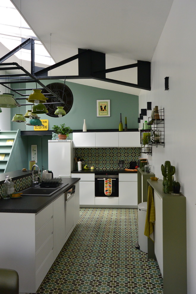 Inspiration for an eclectic l-shaped green floor open concept kitchen remodel in Paris with a drop-in sink, flat-panel cabinets, white cabinets, green backsplash, white appliances and an island