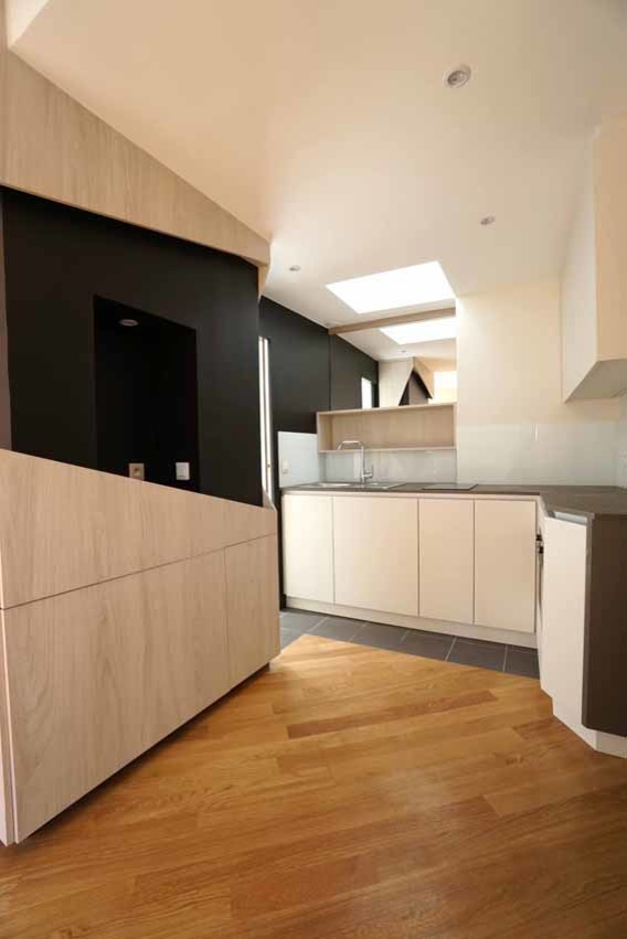 Idéer för ett litet modernt kök, med en enkel diskho, luckor med profilerade fronter, vita skåp, laminatbänkskiva, beige stänkskydd, spegel som stänkskydd, integrerade vitvaror, klinkergolv i keramik och svart golv