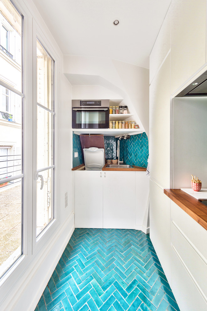 Exempel på ett mellanstort modernt brun brunt kök, med vita skåp, träbänkskiva, blått stänkskydd, stänkskydd i terrakottakakel, klinkergolv i keramik, blått golv, en enkel diskho, luckor med profilerade fronter och integrerade vitvaror