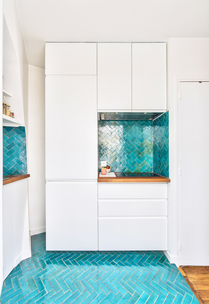 Mid-sized trendy l-shaped ceramic tile and blue floor open concept kitchen photo in Paris with white cabinets, wood countertops, blue backsplash, terra-cotta backsplash, no island, an undermount sink, beaded inset cabinets, paneled appliances and brown countertops