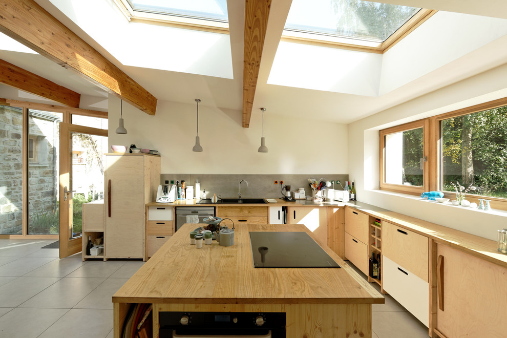 Idéer för ett modernt beige l-kök, med en nedsänkt diskho, släta luckor, träbänkskiva, integrerade vitvaror, en köksö och grått golv