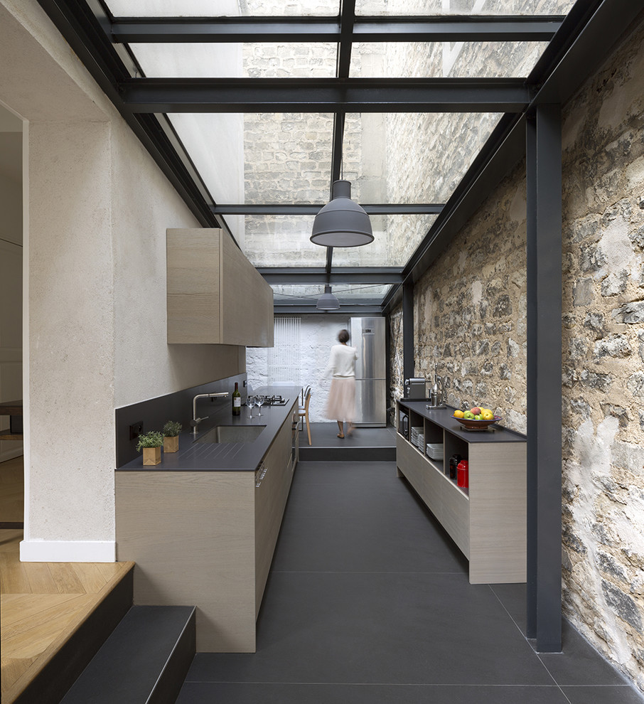 This is an example of a medium sized modern galley kitchen in Paris with a submerged sink, flat-panel cabinets and no island.