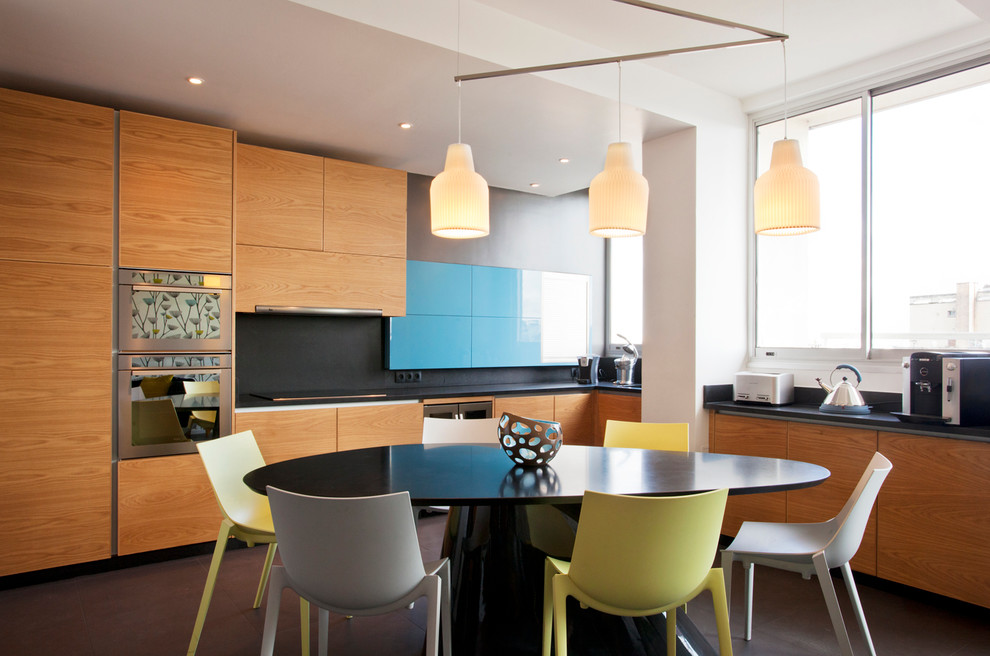 Photo of a medium sized contemporary l-shaped kitchen/diner in Paris with flat-panel cabinets and medium wood cabinets.