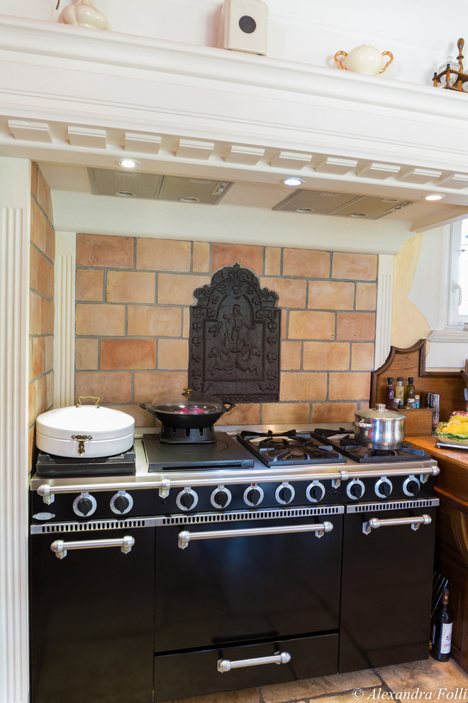 Foto de cocina mediterránea con electrodomésticos negros