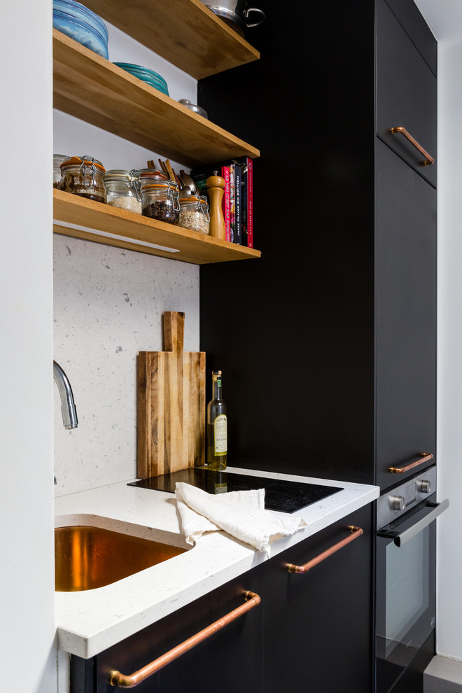Idee per una piccola cucina lineare design con ante lisce, ante nere, top in quarzite, paraspruzzi bianco, nessuna isola, top bianco, lavello sottopiano e elettrodomestici in acciaio inossidabile