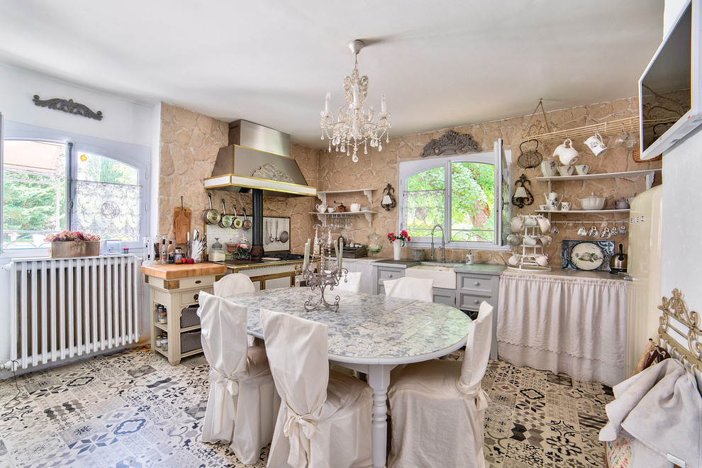 Immagine di una cucina abitabile shabby-chic style con lavello stile country e pavimento multicolore