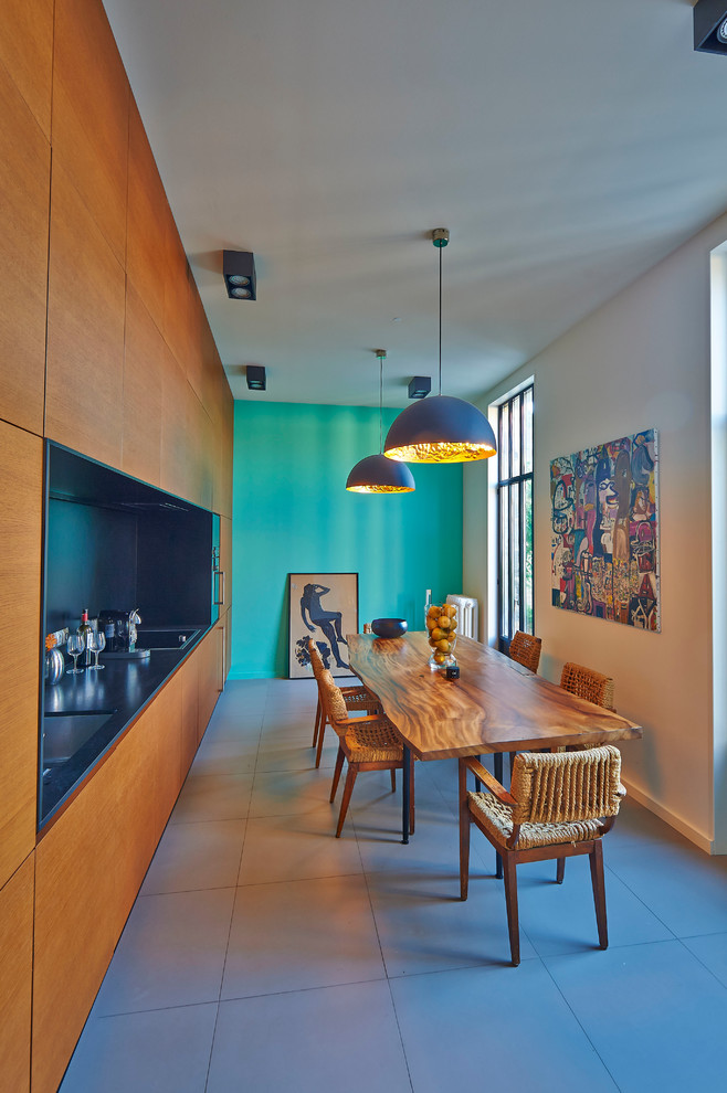 ボルドーにある高級なコンテンポラリースタイルのおしゃれなキッチン (中間色木目調キャビネット、黒いキッチンパネル、セラミックタイルの床、アイランドなし) の写真