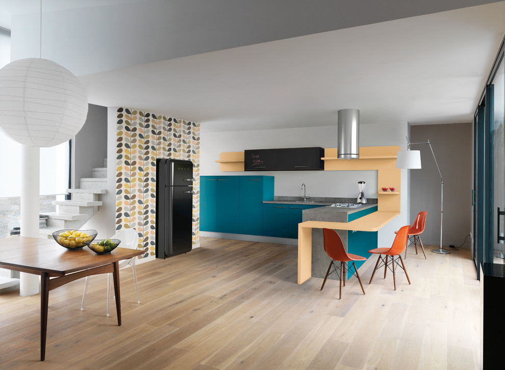 Medium sized retro l-shaped open plan kitchen in Nantes with blue cabinets, laminate countertops, grey splashback, an island, beaded cabinets and black appliances.