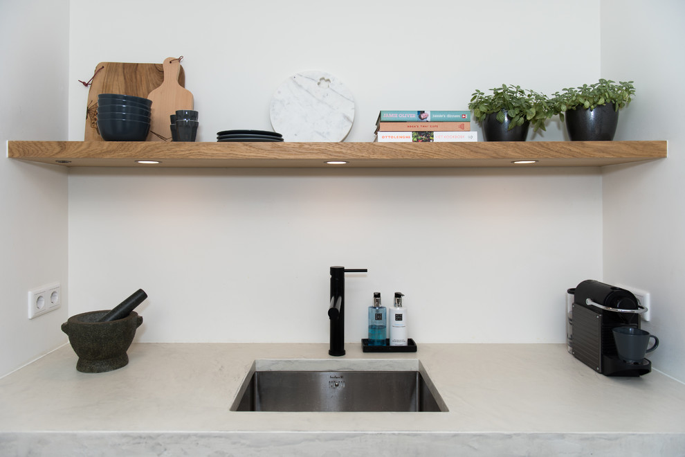 Photo of a small scandinavian single-wall open plan kitchen in Amsterdam with an integrated sink, flat-panel cabinets, wood worktops, white splashback, terracotta splashback, stainless steel appliances, concrete flooring, a breakfast bar, grey floors and white worktops.