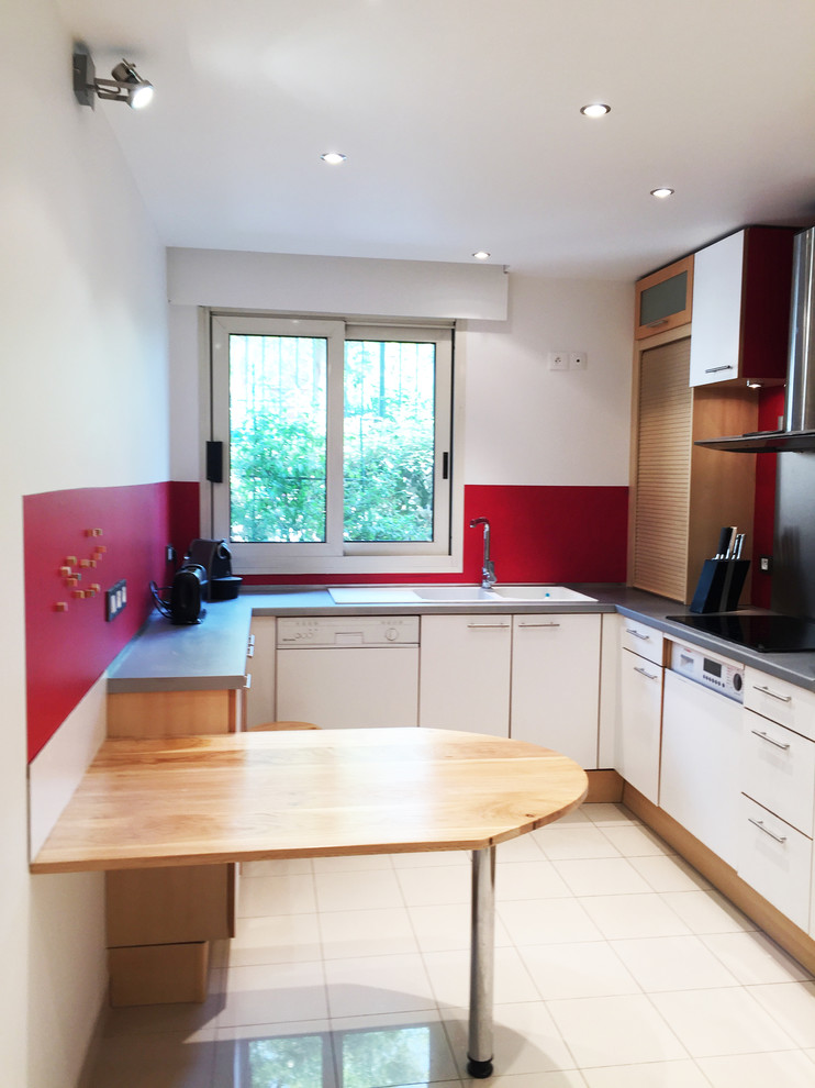 Photo of a medium sized modern u-shaped enclosed kitchen in Paris with a built-in sink, flat-panel cabinets, white cabinets, laminate countertops, red splashback, white appliances, ceramic flooring, a breakfast bar and beige floors.