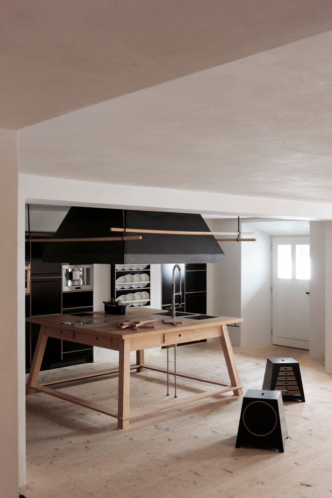 На фото: отдельная, прямая кухня среднего размера в современном стиле с черными фасадами и островом с