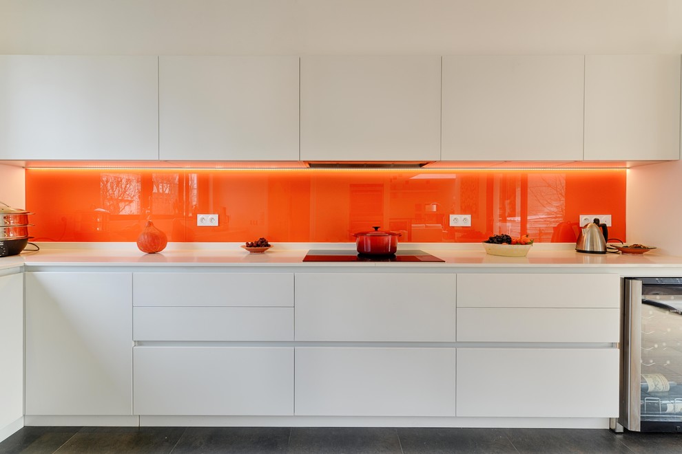 Aménagement d'une cuisine contemporaine avec une crédence orange.