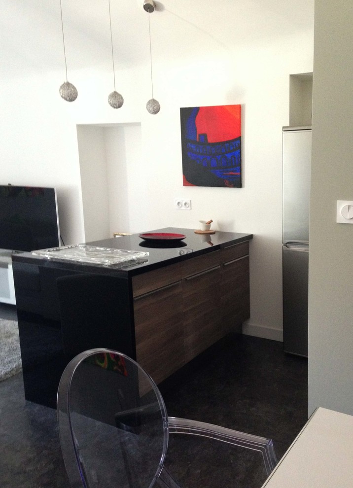 Cette image montre une petite cuisine parallèle design avec un placard à porte affleurante, des portes de placard noires, un plan de travail en surface solide, un électroménager en acier inoxydable, un sol en linoléum, une péninsule et un sol noir.
