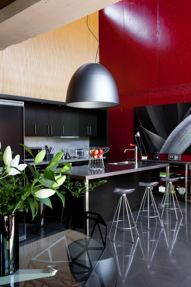 Ispirazione per una grande cucina design con ante lisce, ante in legno bruno, paraspruzzi grigio e pavimento in cemento