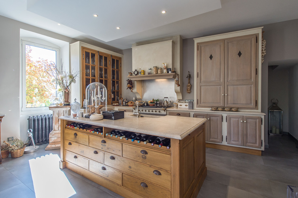 Inspiration for a rural kitchen in Marseille with a single-bowl sink, marble worktops, an island, raised-panel cabinets, medium wood cabinets, grey floors and beige worktops.