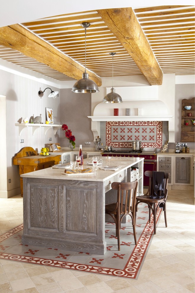 На фото: угловая кухня среднего размера в средиземноморском стиле с фасадами с выступающей филенкой, серыми фасадами, разноцветным фартуком, техникой из нержавеющей стали, островом и обеденным столом