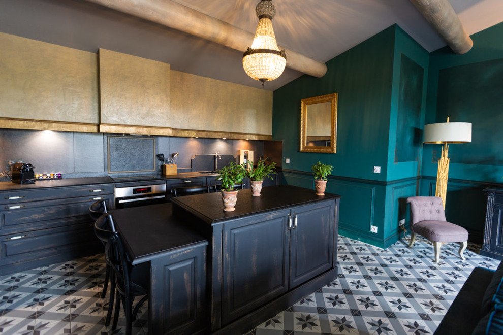 Foto di una cucina eclettica con ante con bugna sagomata, ante con finitura invecchiata, paraspruzzi nero, pavimento multicolore e top nero