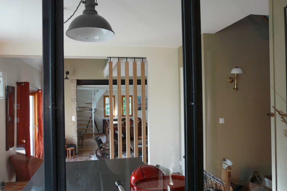 レンヌにあるお手頃価格の広いインダストリアルスタイルのおしゃれなキッチン (インセット扉のキャビネット、ベージュのキャビネット、ラミネートカウンター、黒いキッチンパネル、テラコッタタイルの床、赤い床) の写真
