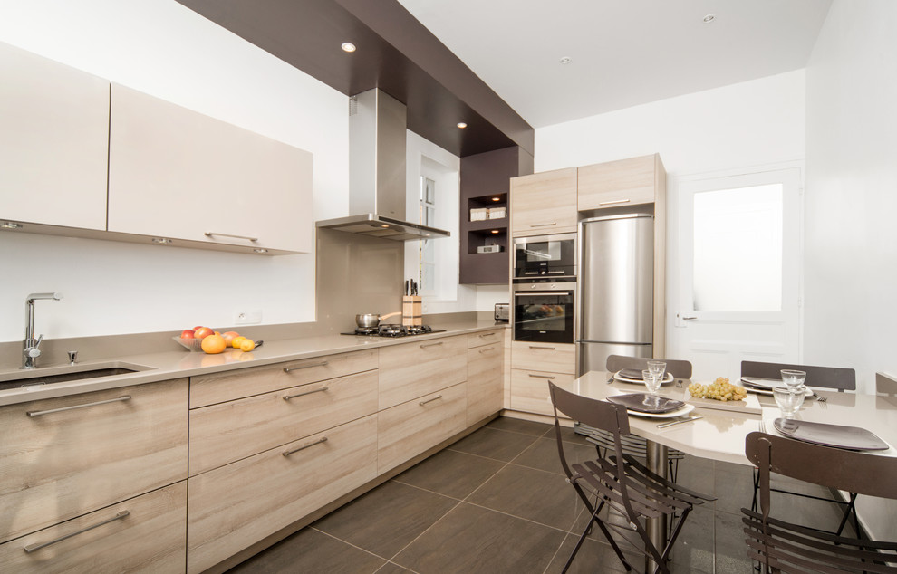 Esempio di una grande e color tortora cucina design con lavello sottopiano, ante lisce, ante in legno chiaro e elettrodomestici in acciaio inossidabile