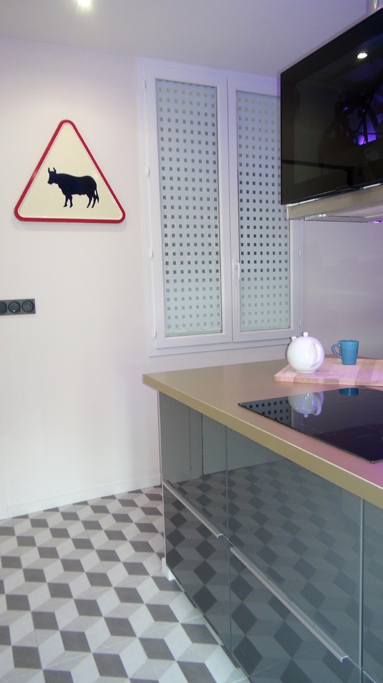 Immagine di una piccola cucina design con lavello sottopiano, ante di vetro, ante nere, top in acciaio inossidabile, paraspruzzi beige, paraspruzzi con piastrelle di metallo, elettrodomestici da incasso e parquet scuro