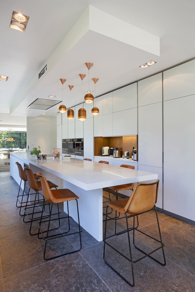 Zweizeilige Moderne Küche mit flächenbündigen Schrankfronten, weißen Schränken und Kücheninsel in Brüssel