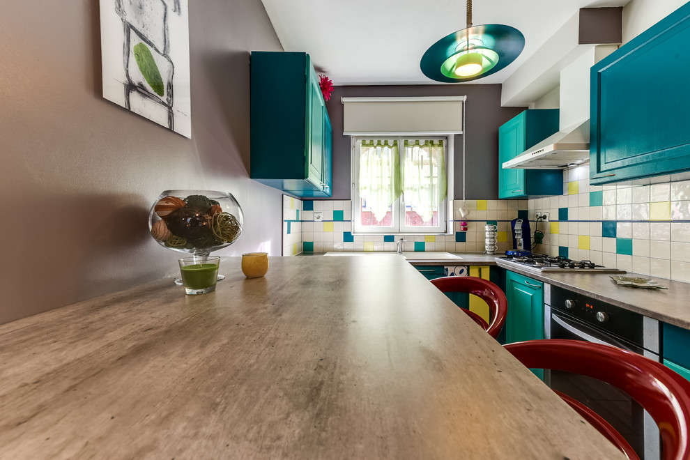 This is an example of a small contemporary l-shaped kitchen/diner in Other with a double-bowl sink, recessed-panel cabinets, turquoise cabinets, laminate countertops, multi-coloured splashback, ceramic splashback, white appliances, ceramic flooring, an island and beige floors.