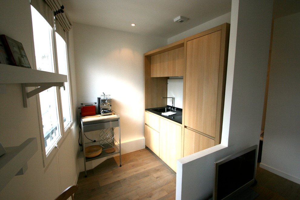 Exemple d'une petite cuisine ouverte linéaire et encastrable scandinave en bois clair avec un évier encastré, un placard à porte affleurante, un plan de travail en granite, une crédence blanche, une crédence en bois et parquet clair.