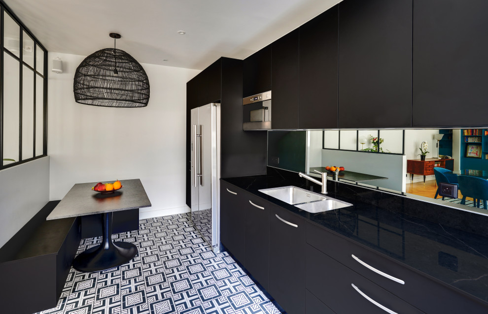 パリにある高級な中くらいなコンテンポラリースタイルのおしゃれなキッチン (アンダーカウンターシンク、インセット扉のキャビネット、黒いキャビネット、大理石カウンター、ミラータイルのキッチンパネル、シルバーの調理設備、セメントタイルの床、アイランドなし、黒い床、黒いキッチンカウンター) の写真