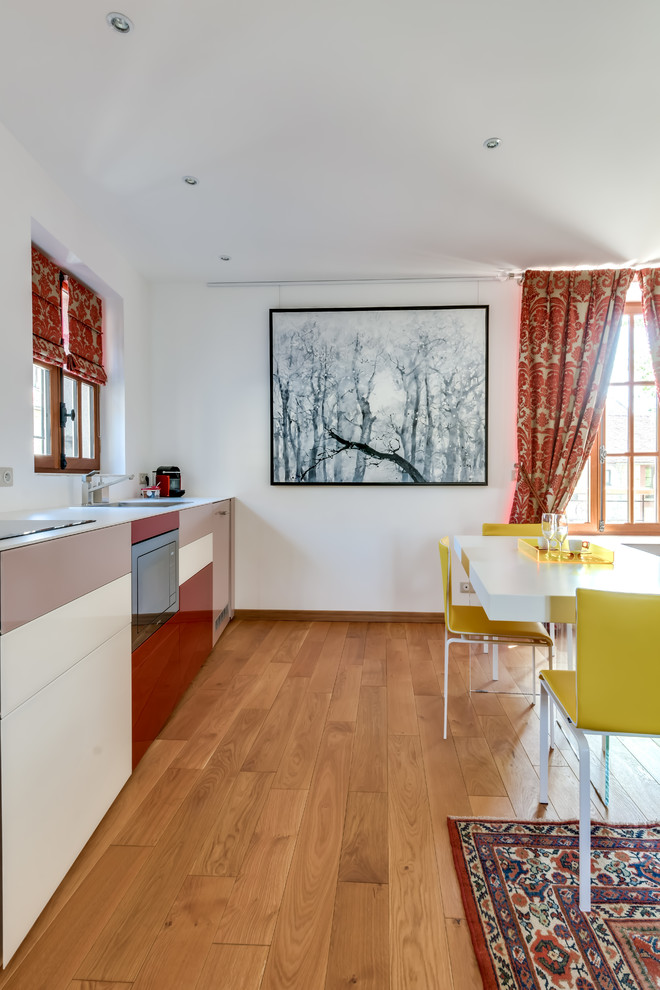 Einzeilige, Mittelgroße Moderne Wohnküche ohne Insel mit Waschbecken, Quarzwerkstein-Arbeitsplatte, Elektrogeräten mit Frontblende und hellem Holzboden in Paris