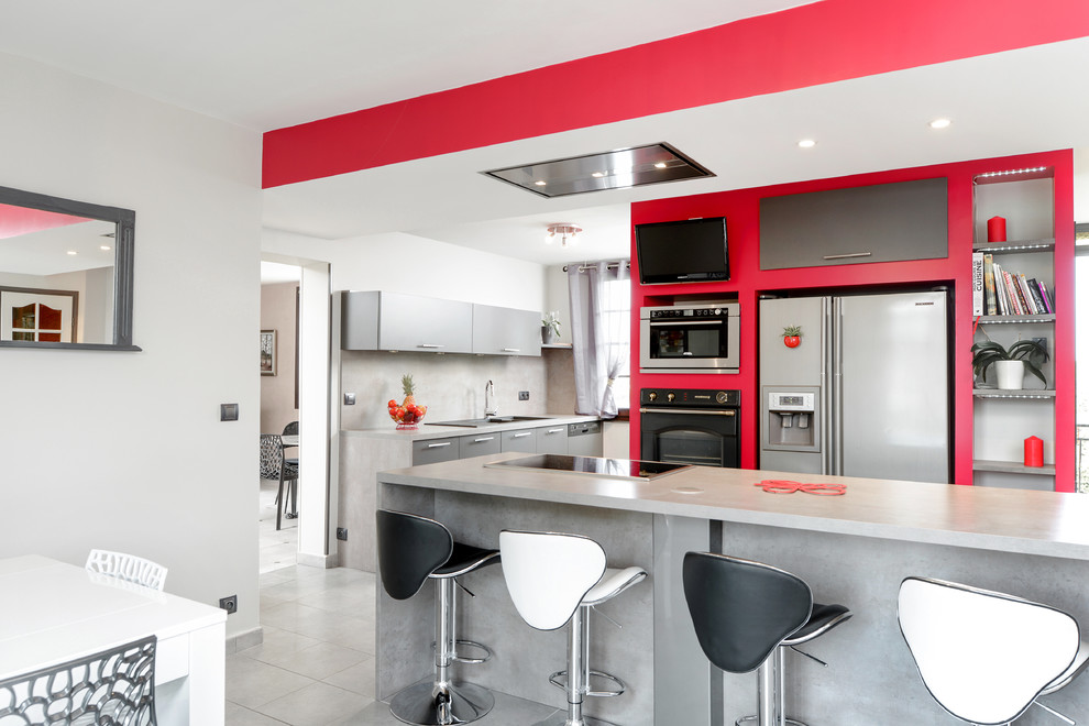 Große Moderne Wohnküche in L-Form mit flächenbündigen Schrankfronten, grauen Schränken, Küchenrückwand in Grau, Küchengeräten aus Edelstahl und Kücheninsel in Lyon